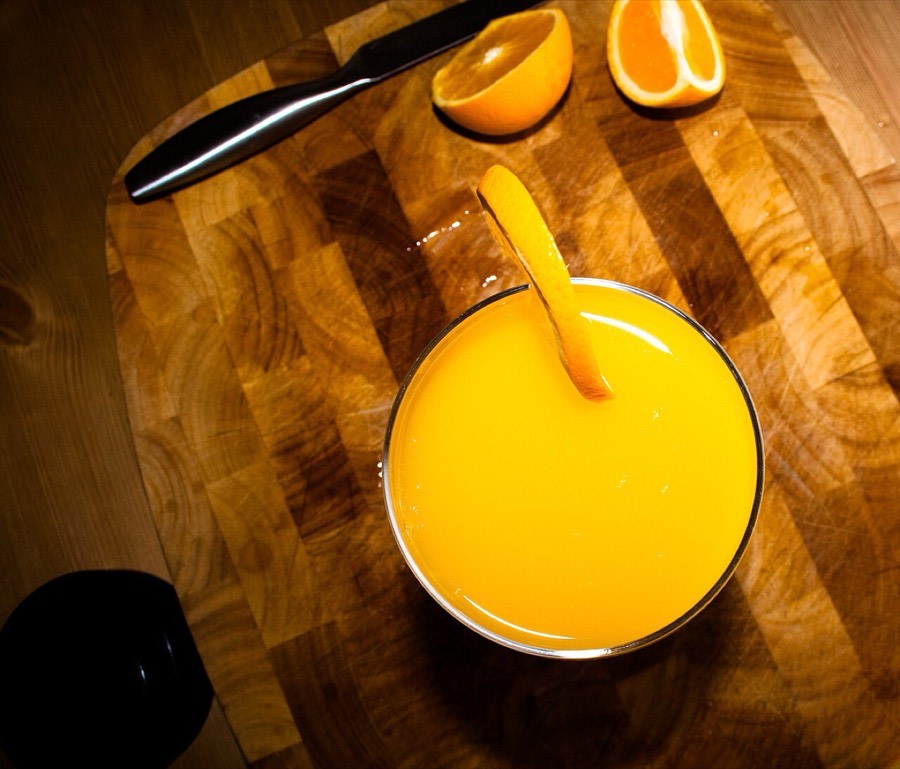 Stiklinė šviežiai spaustų obuolių sulčių šalia obuolių